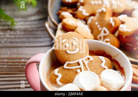 Rosa Becher mit heißer Schokolade und Marshmallows Gingerbread Man Nahaufnahme Stockfoto