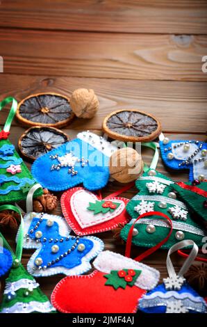 Verschiedene handgefertigte rustikalen fühlte Christbaumschmuck mit Anis, Zimt und Walnüssen auf hölzernen Tisch Stockfoto