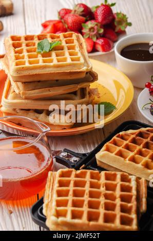 Belgische Waffeln auf gegossenen Pfanne mit gestapelten und Sirup Krug beiseite Stockfoto