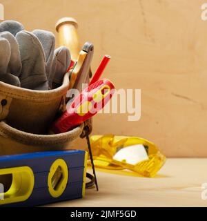 Nahaufnahme am Werkzeuggürtel mit Tischlerwerkzeugen und Schutzbrille Stockfoto