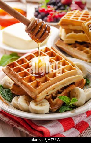 Belgische Waffeln serviert mit Butter Banane Minze Blatt und Sirup Stockfoto