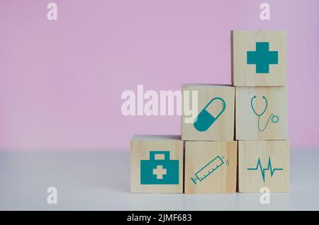 Holzwürfel Block mit Versicherung Krankenwagen medizinischen Symbol auf dem rosa Hintergrund und kopieren Raum. Stockfoto