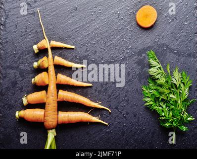 Draufsicht auf stilisierte Weihnachtsbaum von Karotten auf Schiefer tray Stockfoto