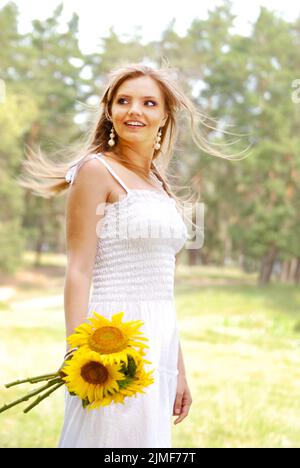 Schöne junge blonde Frau im weißen Kleid Stockfoto