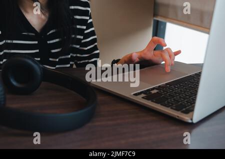 Nahaufnahme Hand Mädchen Eingabe Tastatur Computer Laptop digitale Online-Netzwerk Kommunikation Internet auf dem Tisch. Stockfoto