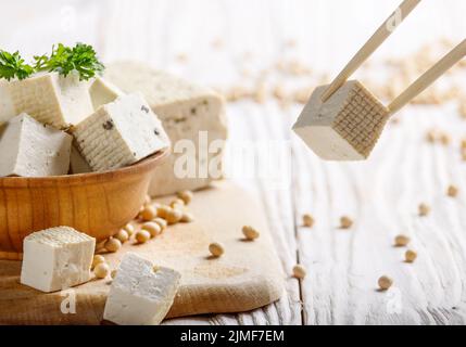 Soja Tofu Tofu in Houten auf weißen Küche aus Holz Tisch. Pflanzliche alternative Ersatz für Käse. Für text Stockfoto