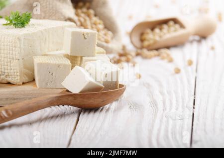 Soja Tofu Tofu auf Schneidebrett und in Hanf sack auf weiße Küche aus Holz Tisch. Platz für Text Stockfoto