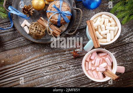 Flacher Weihnachtshintergrund aus zwei Tassen heißer Schokolade mit Marshallows, Fichtenzweig und Tablett mit Lebkuchen Stockfoto