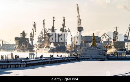 Der Bau von nuklearen Eisbrechern, Kränen der baltischen Werft in einem frostigen Wintertag, Dampf über dem Fluss Neva, smo Stockfoto