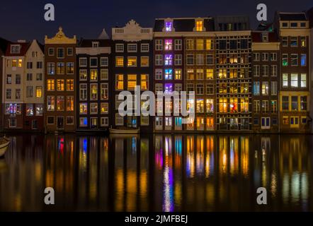 Tanzende Häuser auf dem Amsterdamer Kanal bei Nacht Stockfoto