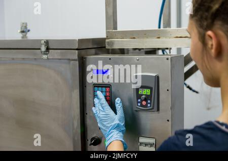 Frau, die in der Industrie arbeitet und Ausrüstung anpasst Stockfoto