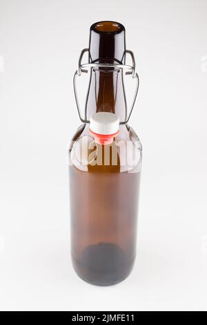 Bierflaschen aus dunklem Glas mit isoliertem Deckel auf weißem Hintergrund Stockfoto