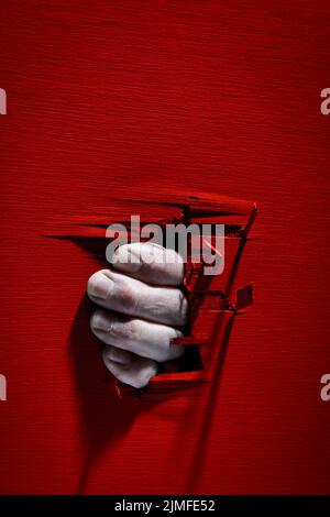 Finger durch einen Holzspalt. Stockfoto