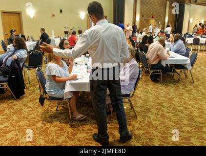 Calvert City, KY, USA. 05 August 2022. Drew Williams, Vorsitzender des Exekutivkomitees der Demokratischen Partei von Marshall County (Mitte), spricht mit Gästen beim 25. Mike Miller Memorial Marshall County Bean Dinner im Kentucky Dam Village State Resort Park. Die Spendenaktion der Marshall County Democratic Party findet in der Nacht vor dem jährlichen St. Jerome Fancy Farm Picnic statt, dem traditionellen Beginn der politischen Wahlkampfsaison in Kentucky. (Kredit: Billy Suratt/Apex MediaWire über Alamy Live News) Stockfoto