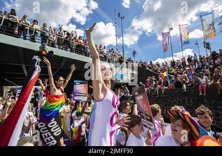 2022-08-06 12:31:03 Teilnehmer auf einem Boot und Menge am Kai während der Canal Parade in Amsterdam, Samstag, 6. August. Nach zwei Jahren Abwesenheit wird wieder die Bootsparade stattfinden, der Höhepunkt von Pride Amsterdam. ANP EVA PLEVIER niederlande Out - belgien Out Stockfoto