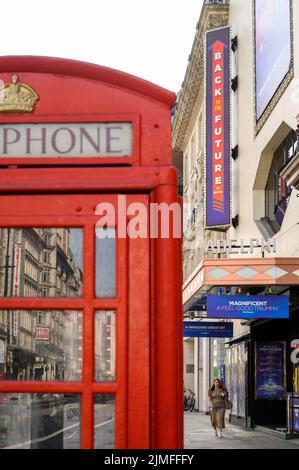 LONDON - 18. Mai 2022: Adelphi Theater Eingang mit traditioneller roter britischer Telefonbox im Vordergrund Stockfoto