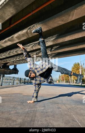 Junger Mann bricht Tänzer tanzen auf städtischen Hintergrund akrobatische Stunts Durchführung Stockfoto