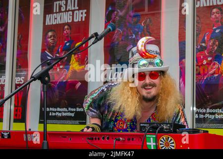 Falling Apart' in Ilfracombe ansässiger Punk Rock & Roll Cabaret-Keyboarder. Noel 'Vomit' Grummitt - 'der Professor' für Punk-Subkultur, Ideologien, Mode, wat beim Punk Rebellion Festival in den Winter Gardens. Ein Protest gegen konventionelle Einstellungen und Verhaltensweisen, ein Aufeinanderprallen von Anti-Establishment-Kulturen, eine Menge Haltung in der Küstenstadt, da Punks, die am jährlichen Rebellion Rock Music Festival in den Wintergärten teilnehmen, Seite an Seite mit traditionellen Urlaubern stehen. Stockfoto