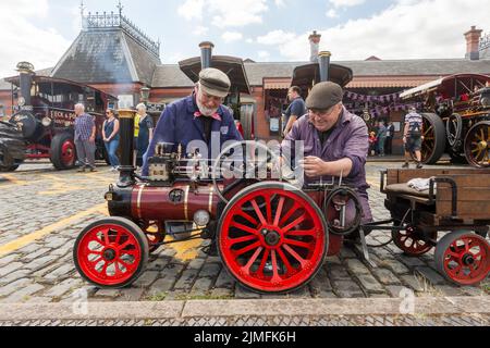 Kidderminster, Worcs, Großbritannien. 6. August 2022. Die Dampfenthusiasten von Vater und Sohn Les und Ian Bromley, 83 und 53, verfeinern ihre Miniatur-Dampftraktionsmaschine Pride and Joy, eine Marshall-Dampftraktionsmaschine im Maßstab 1:4 von Sidbury, bei der Vintage Transport Extravaganza der Severn Valley Railway in Kidderminster, Worcestershire. Sie bauten den Motor von Hand und nahmen über 2.000 Stunden Expertenarbeit in Anspruch. Die jährliche Veranstaltung umfasst Oldtimer-Fahrzeuge sowie Dampfmaschinen. Kredit: Peter Lopeman/Alamy Live Nachrichten Stockfoto