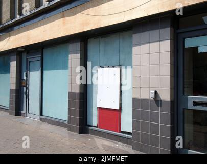 Verlassene, geschlossene Hausbank oder Ladenfront mit vertauften und überdachten Fenstern Stockfoto