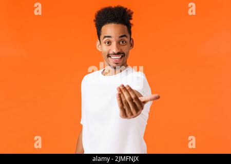 Kommen Sie mit uns. Glückliche und freundliche ausgehende afroamerikanische moderne männliche Student einladen teilnehmen, Einstellung, machen hierher kommen g Stockfoto
