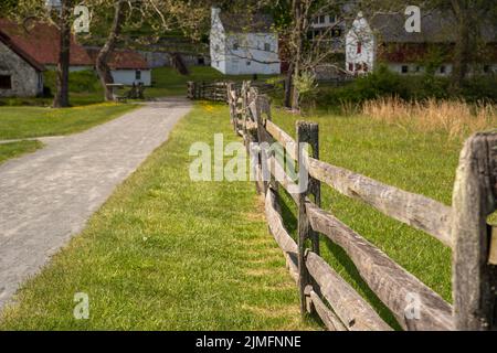 Holzzaun entlang des Wanderweges führt zum kolonialen amerikanischen Dorf. Stockfoto