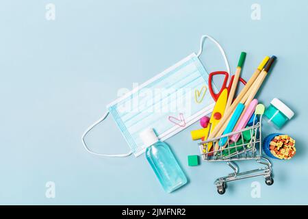 Schulbedarf, poppit Anti-Stress, Gesichtsmaske, Flasche Desinfektionsmittel, für den Rückweg in die Schule auf blauem Hintergrund. Covid-19 Vorsichtsmaßnahmen, gesund zu bleiben. T Stockfoto