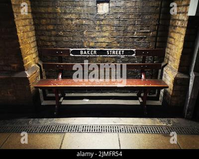 Alte und alte Bank in der U-Bahnstation Baker Street, in einer dunklen und geheimnisvollen Atmosphäre, London, England, Großbritannien. Stockfoto