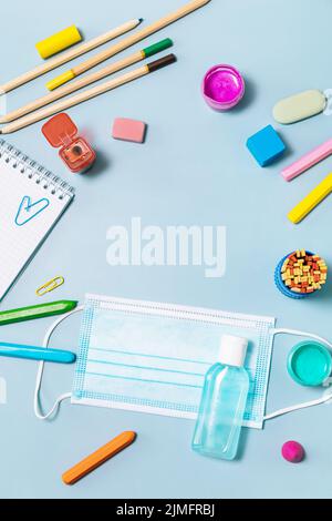 Schulbedarf, poppit Anti-Stress, Gesichtsmaske, Flasche Desinfektionsmittel, für den Rückweg in die Schule auf blauem Hintergrund. Covid-19 Vorsichtsmaßnahmen, gesund zu bleiben. T Stockfoto