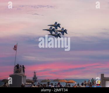 Wantagh, New York, USA - 29. Mai 2022: Vier Blue Angels der US Navy fliegen in Formation über einem Rettungsschwimmer während des Sonnenuntergangs am Strand während eines ai Stockfoto