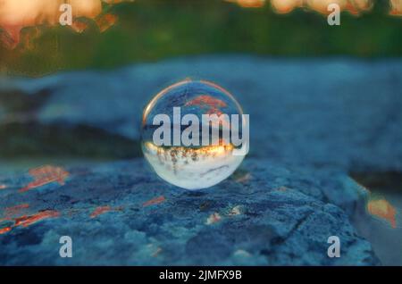 Der Sonnenuntergang im Shenandoah-Nationalpark spiegelt sich in einem Crystal Ball wider, der auf einem flachen Felsen ruht. Stockfoto