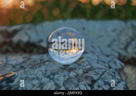 Der Sonnenuntergang im Shenandoah-Nationalpark spiegelt sich in einem Crystal Ball wider, der auf einem flachen Felsen ruht. Stockfoto