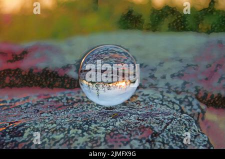 Der Sonnenuntergang im Shenandoah-Nationalpark spiegelt sich in einem Crystal Ball wider, der auf einem flachen Felsen ruht. Stockfoto