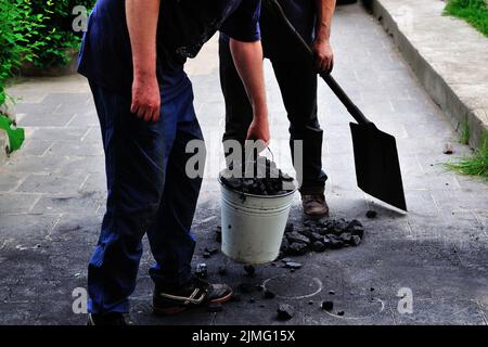 Geschäft, Kohle, Entladen, Brennen, Heizen, Energie, Winter, Alltag, Menschen, Menschen, Warm, Zubehör, Arbeit, schwer, Service, Heizung, Winter Stockfoto