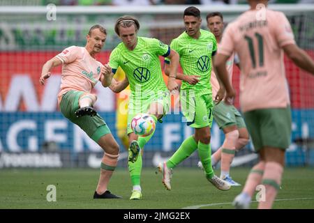 Wolfsburg, Deutschland. 06. August 2022. Fußball, Bundesliga, VfL Wolfsburg - SV Werder Bremen, Matchday 1, Volkswagen Arena. Der Bremer Christian Groß (l) spielt gegen den Wolfsburger Patrick Wimmer. Dahinter wacht der Wolfsker Josip Brekalo auf. Quelle: Swen Pförtner/dpa - WICHTIGER HINWEIS: Gemäß den Anforderungen der DFL Deutsche Fußball Liga und des DFB Deutscher Fußball-Bund ist es untersagt, im Stadion und/oder vom Spiel aufgenommene Fotos in Form von Sequenzbildern und/oder videoähnlichen Fotoserien zu verwenden oder zu verwenden./dpa/Alamy Live News Stockfoto