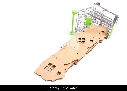 Umgedrehter Miniatur-Schiebewagen und hölzerne Spielzeughausteile isoliert auf weißem Hintergrund. Bauindustriebezogenes Konzept. Stockfoto