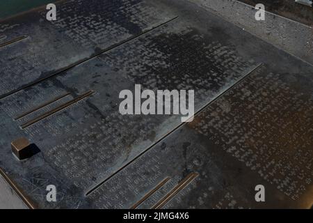 Teil einer Bronzetafel am Rheinufer, mit Text in Braille, der Blinden und Sehbehinderten die Sehenswürdigkeiten von Basel erklärt Stockfoto