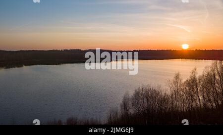 Luftaufnahme von einer Drohne eines wunderschönen dramatischen und farbenfrohen Sonnenuntergangs an der Küste des Sees. Naturlandschaft. Natur in Europa Stockfoto