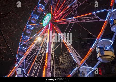 Das Riesenrad wird nachts in Leeds vom Rathaus wunderschön beleuchtet. Stockfoto