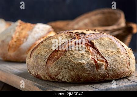 Handgemachtes Sauerteig-Brot auf einem Holzregal. Stockfoto