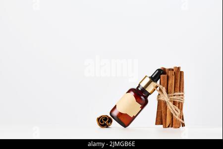 Braune Glasflasche mit leerem Papieretikett und Pipette. Kosmetische Verpackungen, Werbung und Werbung Stockfoto