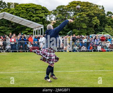 North Berwick, East Lothian, Schottland, Großbritannien, 6.. August 2022. North Berwick Highland Games: Die jährlichen Spiele finden auf dem Erholungsgebiet statt. Im Bild: Ein Mann mit einem Kilt nimmt am Put-Wettbewerb Teil Stockfoto
