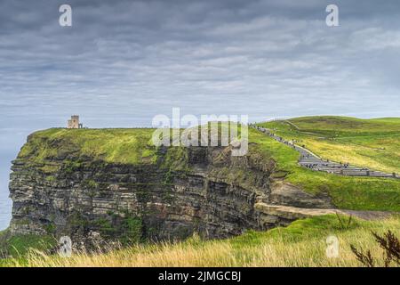 Massen von Touristen, die über Treppen zum OBriens Tower auf den berühmten Cliffs of Moher, Irland, laufen Stockfoto