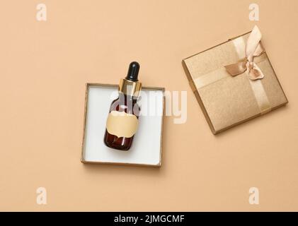 Glasflasche mit Papier leerem Etikett in einer Schachtel, Draufsicht. Behälter für Kosmetika, Aromaöle Stockfoto