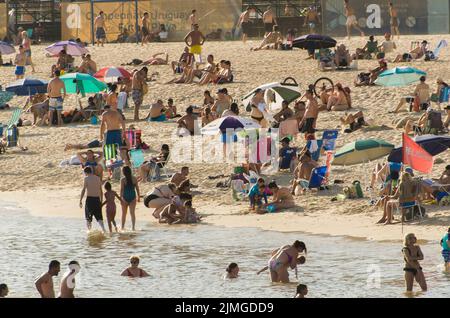 Montevideo, Uruguay - 11th. Januar 2022 - wunderschöner Sonnenuntergang am Strand von Pocitos mit Badegäste an einem Sommertag in Montevideo Uruguay. Stockfoto