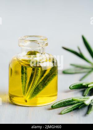 Rosemary wesentliches Öl in kleinen Glas Flasche mit frischem Rosmarin Stockfoto
