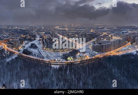 Luftaufnahme Winter Stadtbild von St. Petersburg - Russland in der Dämmerung, Drohne fliegt über riesige Wohnsiedlungen und öffentlichen Park, Bau Stockfoto