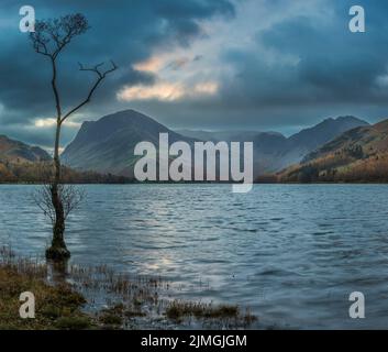 Atemberaubendes Landschaftsbild von Buttermere im Lake District bei Sonnenaufgang im Herbst mit dramatischem stürmischen Himmel Stockfoto