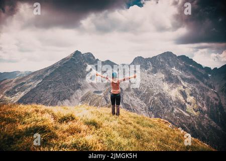 Frau, die die Aussicht in den hohen Bergen genießt Stockfoto