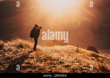 Landschaftsfotograf bei einem schönen nebligen Sonnenaufgang am Morgen Stockfoto